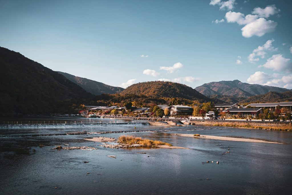 Beautiful landscape of Arashiyama mountains and river in Kyoto, Japan, under a clear blue sky.