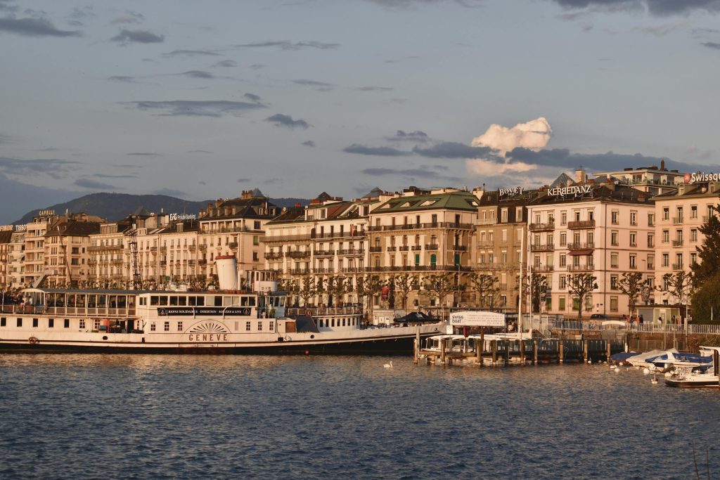 Elegant view of Geneva's waterfront with historic architecture at sunset.