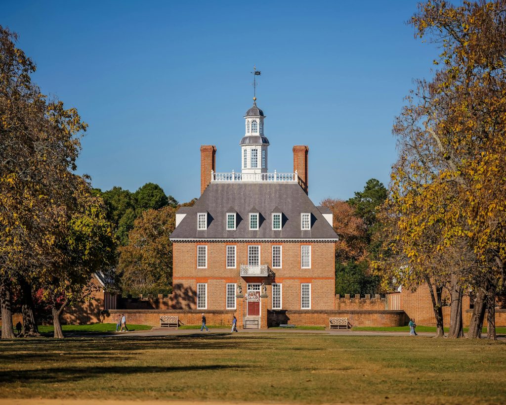 Historic Governor's Palace in Colonial Williamsburg surrounded by autumn foliage.