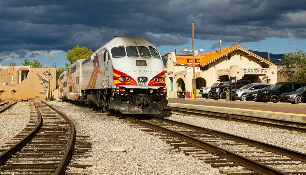 10 January Trips That Feel Like Settling Gently, Not Escaping – Her Life Adventures Rail Runner Express train arriving in Santa Fe, NM under dramatic skies.
