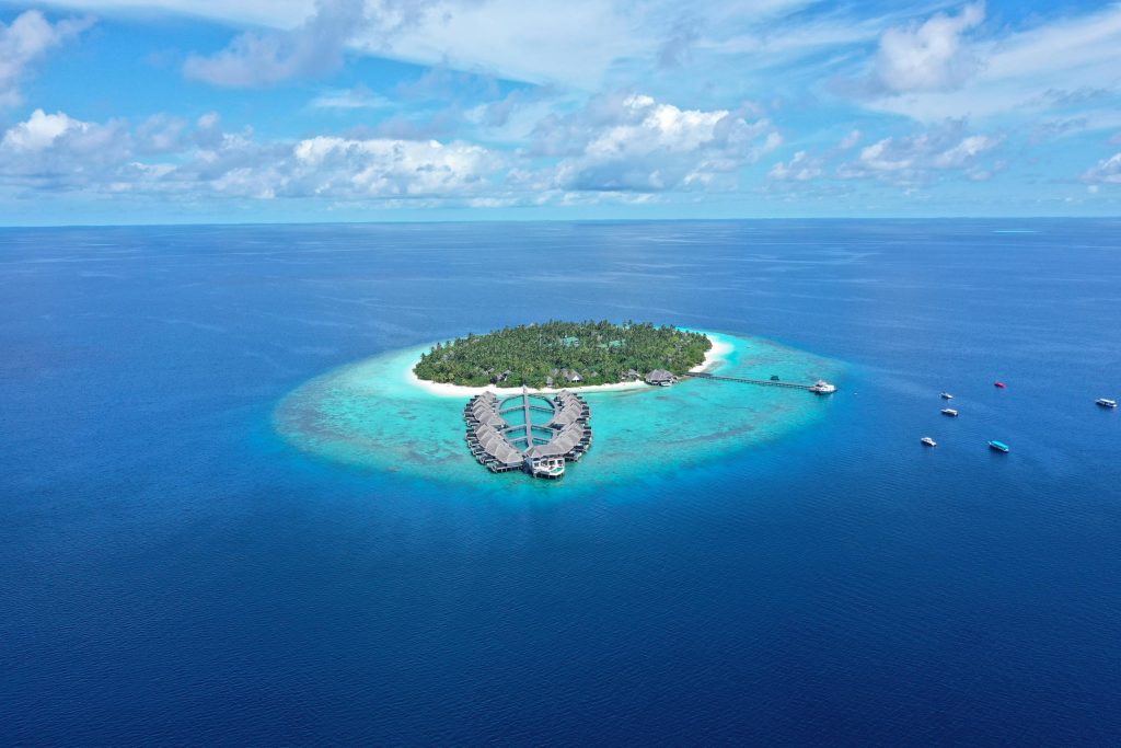 Stunning aerial view of island resort with turquoise waters, Maldives.