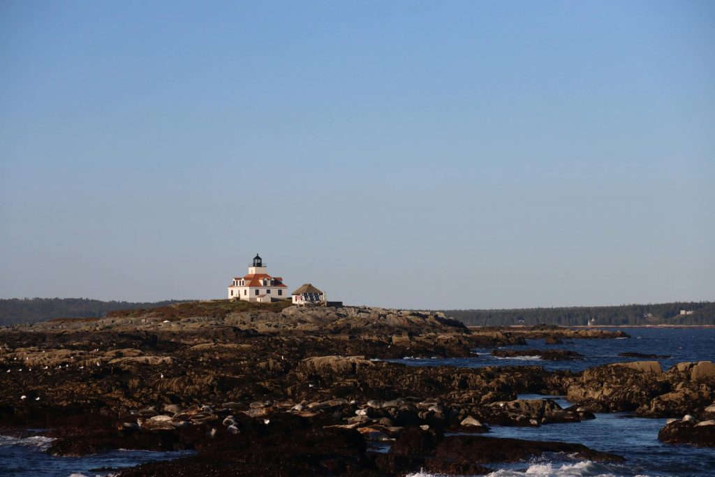 Stunning view of a traditional coastal lighthouse on a rocky shore in Bar Harbor, Maine.