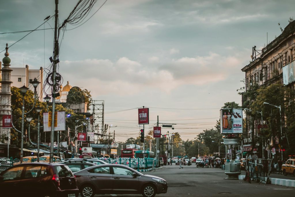 Vibrant street view of Kolkata showcasing city life, architecture, and traffic at dusk.