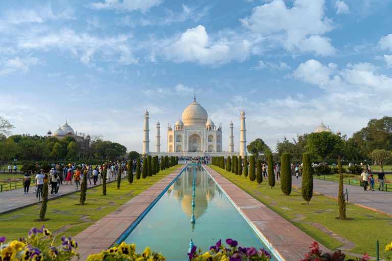 A beautiful view of the Taj Mahal in Agra, India, with clear blue skies and vibrant gardens.