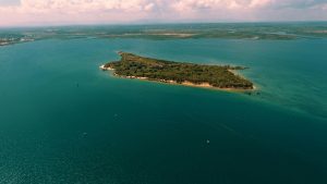 A breathtaking aerial view of an island surrounded by turquoise waters in Tanga, Tanzania.
