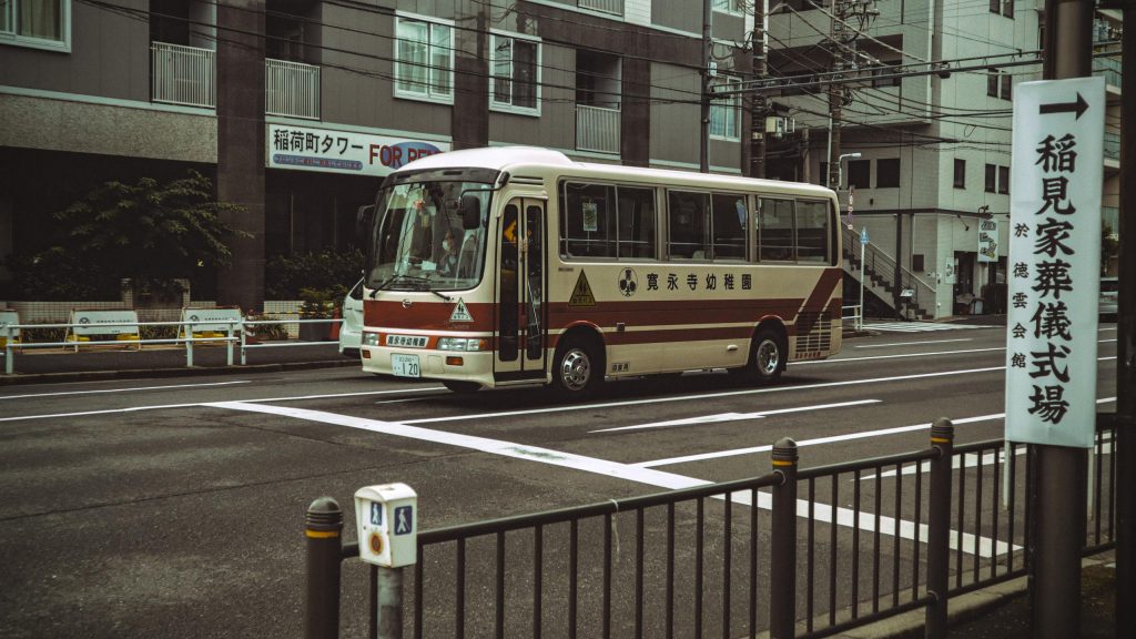 A bus drives through a typical Tokyo street, showcasing urban life in Japan.