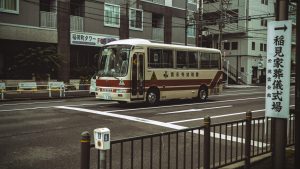 A bus drives through a typical Tokyo street, showcasing urban life in Japan.