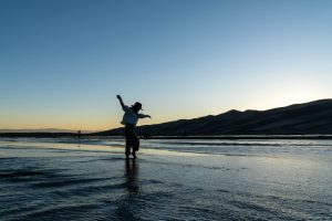 A cowboy silhouetted against the dusk at the stunning Colorado sand dunes, capturing an adventurous spirit.