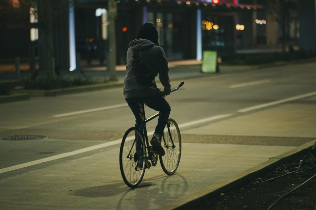 A cyclist rides through the dimly lit streets of Houston, Texas at night.
