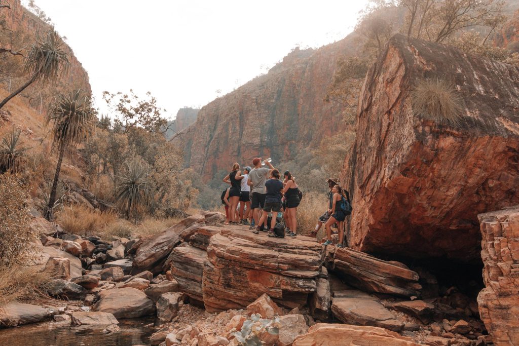 A group of friends hiking and exploring rocky terrain in a scenic canyon.
