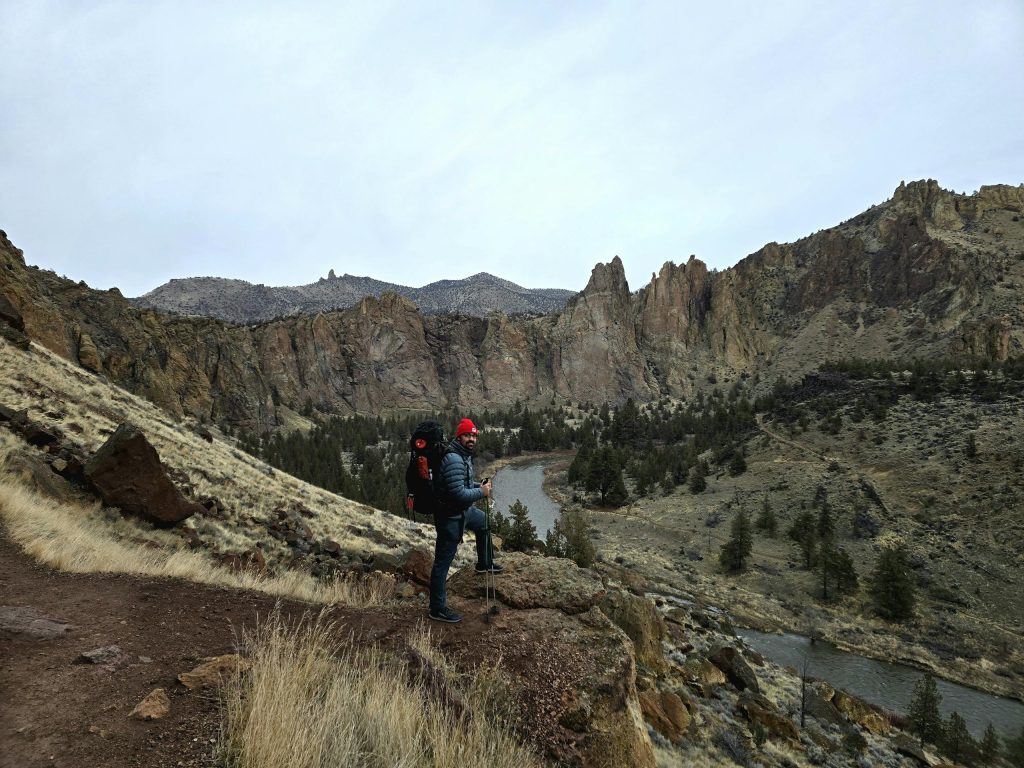 A hiker exploring the rugged terrain of Smith Rock State Park in Oregon.