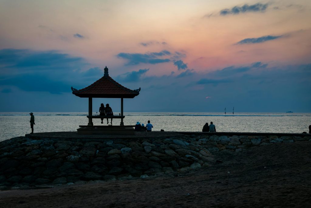 A peaceful evening with a pagoda silhouette at sunset on Kuta Beach, Bali, Indonesia.