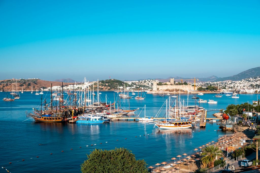 A stunning view of Bodrum's marina with sailboats and the historic Bodrum Castle on a sunny day.