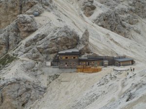 A tranquil mountain refuge nestled in the rocky Italian Alps landscape.