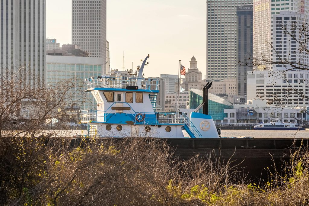 A tugboat on the Mississippi River with the iconic New Orleans skyline in the background.