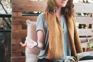 A young woman meditates outdoors, embracing calmness and relaxation.