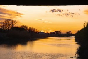 Beautiful sunset over a tranquil river in Porto Fuori, Emilia-Romagna, Italy.