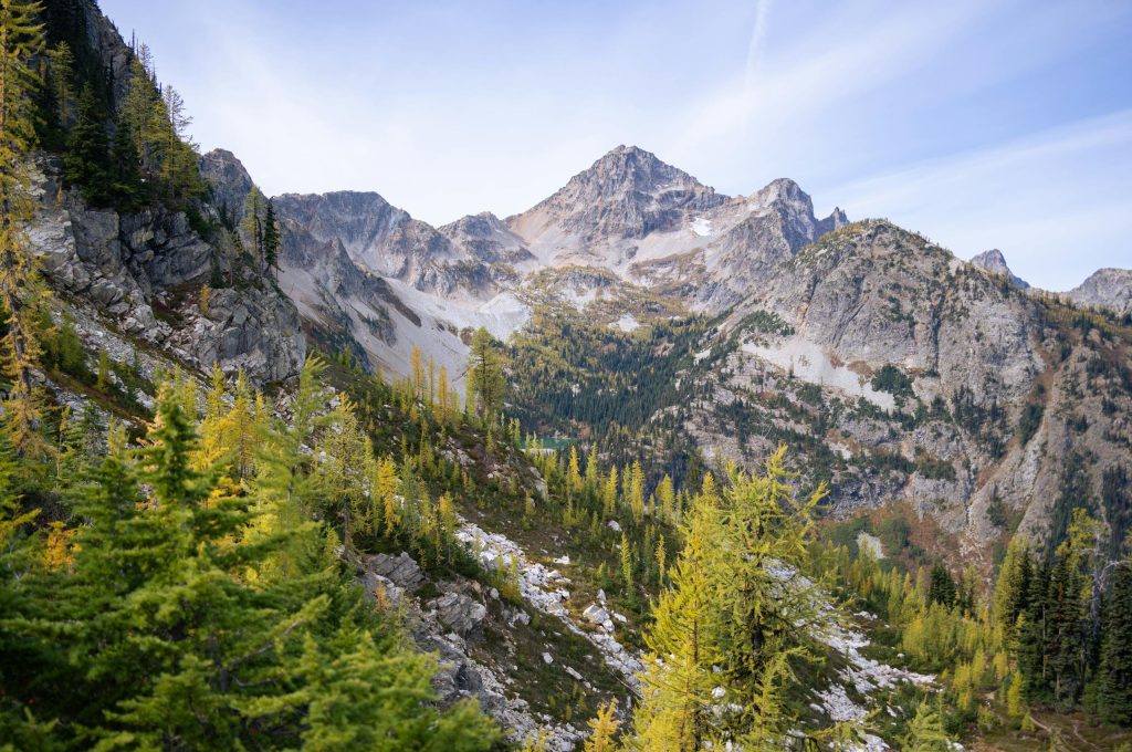 Breathtaking view of mountains and larch trees in Washington's wilderness during autumn.