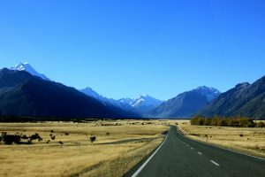 Breathtaking view of the road leading to majestic mountains in Fiordland National Park, New Zealand.