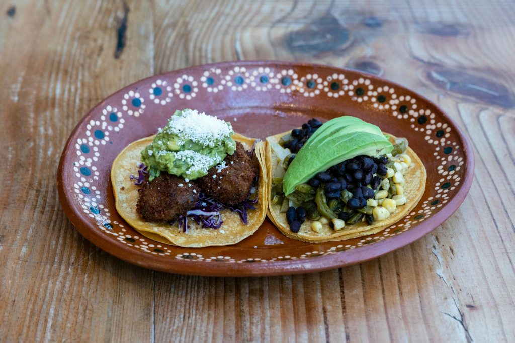 Close-up of delicious homemade tacos with fresh ingredients on a rustic wooden table.