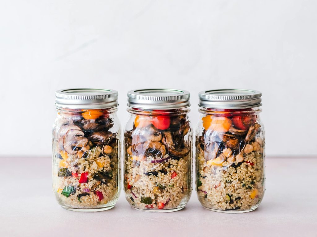 Colorful quinoa salad jar with roasted veggies, ideal for healthy meal prep.