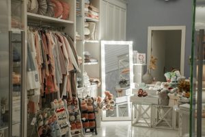 Elegant boutique interior showcasing clothing, textiles, and decorative items in warm tones.