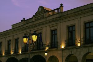 Elegant evening view of the Parador de Ronda with streetlights during dusk in Ronda, Spain.