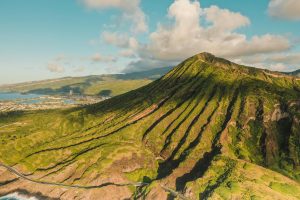 Experience the breathtaking aerial view of Hawaii's lush, sunlit valleys and iconic volcanic formations.