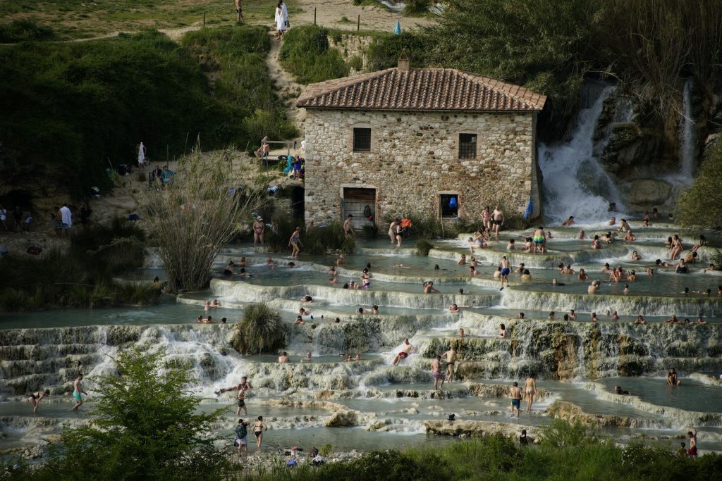 Explore the cascading natural hot springs of Cascate del Mulino in Tuscany, Italy, a serene relaxation spot.