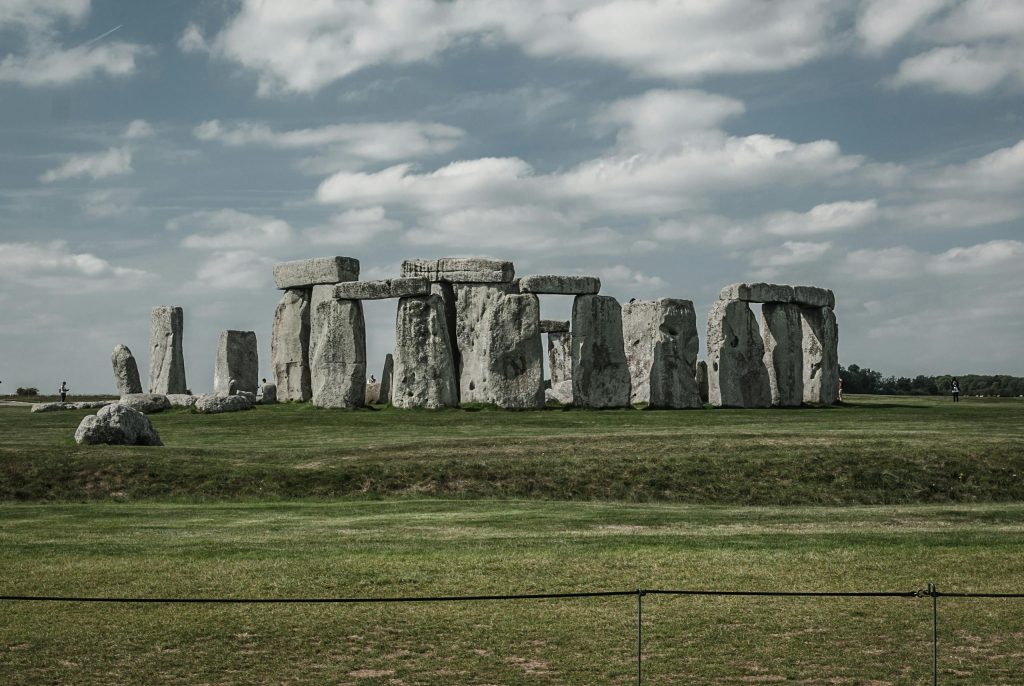 Explore the iconic Stonehenge monument in England, captured under a dramatic sky with lush green grass.
