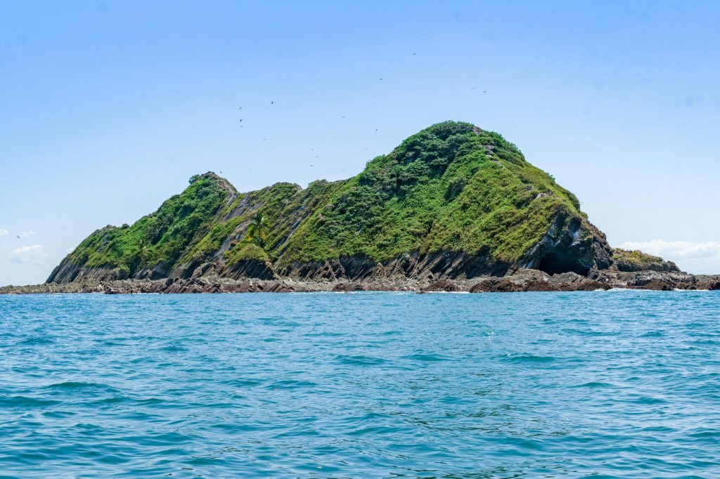 Explore the rocky island terrain surrounded by blue sea in Puntarenas, Costa Rica, captured during summer.