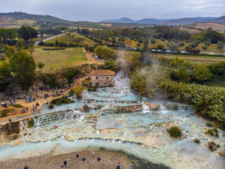 Explore the stunning aerial view of Saturnia hot springs nestled in the Tuscan countryside.