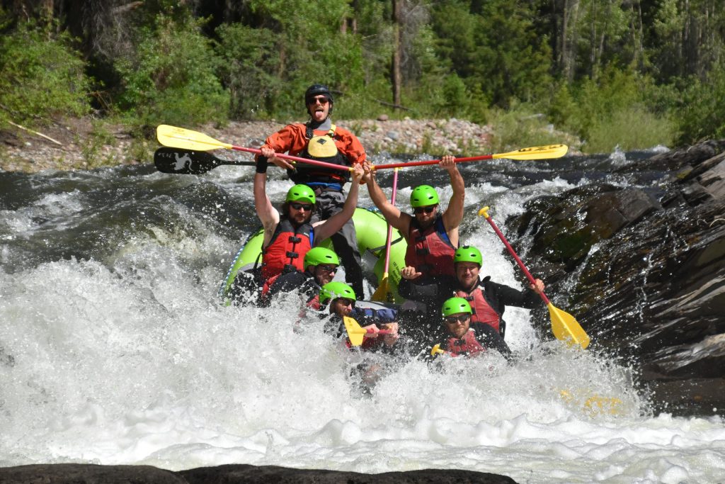 Group of people experiencing thrilling whitewater rafting in Aspen, Colorado.
