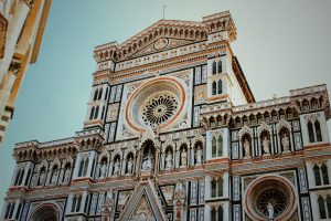 Intricate details of the Florence Cathedral facade showcasing Gothic architecture in bright daylight.