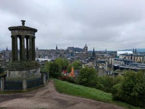 Panoramic view of Edinburgh's historic skyline with Dugald Stewart Monument on Calton Hill.