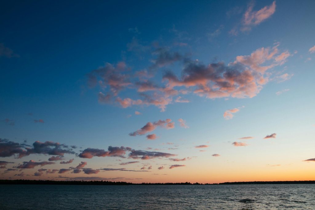 Peaceful sunset view with pink and orange clouds over Lake Michigan in Wisconsin.