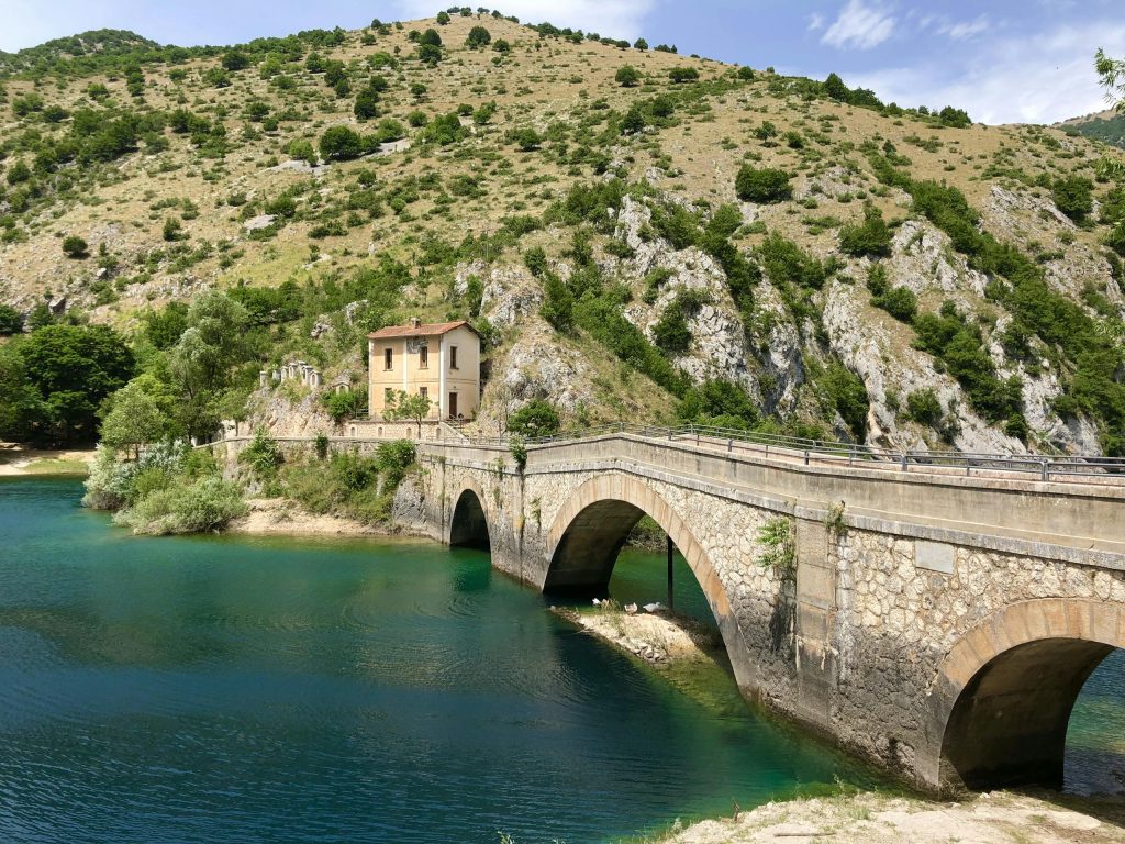 Picturesque view of a stone bridge and hillside in Villalago, Italy, capturing the serene beauty of Abruzzo.