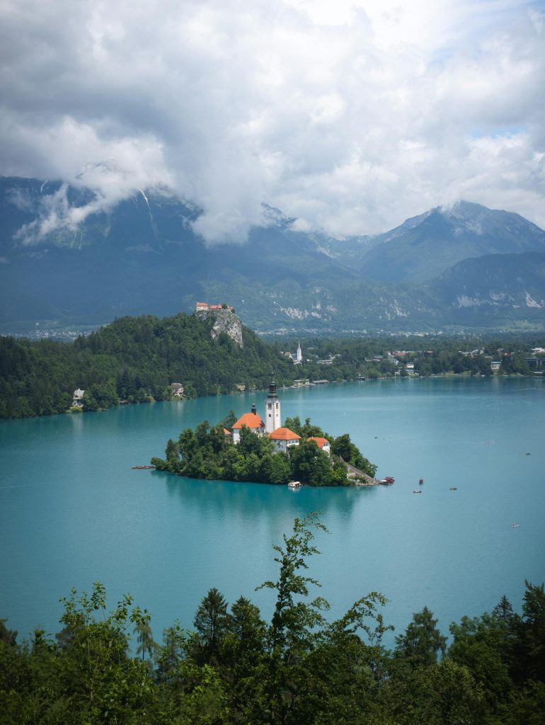 Picturesque view of Lake Bled with the iconic island and church against a mountainous backdrop in Slovenia.