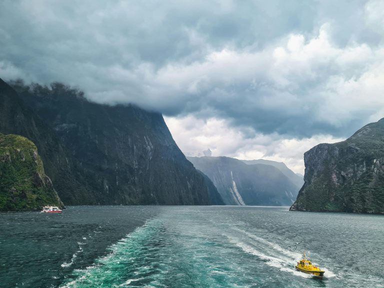 Picturesque view of Milford Sound with boats navigating through stunning fjord landscape in New Zealand.