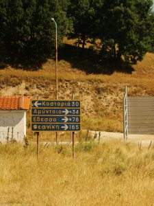 Rural direction sign pointing to Kastoria and Thessaloniki in Kleisoura, Greece.