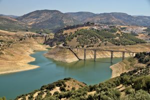 Scenic aerial view of Iznájar Reservoir with bridge and surrounding mountains in Spain.
