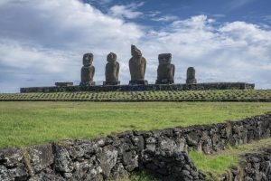 Scenic view of iconic Moai statues under blue skies on Easter Island, Chile.