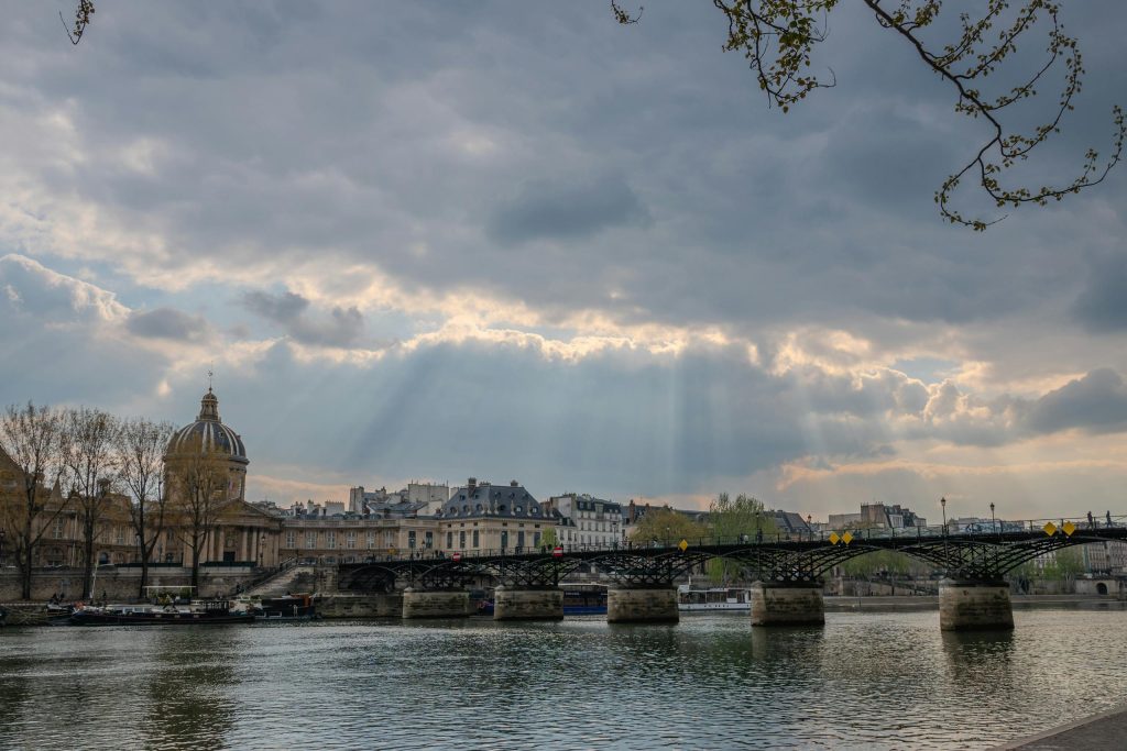 Scenic view of Pont des Arts and Institut de France with dramatic sky in Paris.