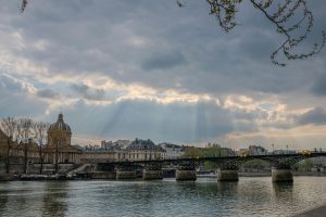 Scenic view of Pont des Arts and Institut de France with dramatic sky in Paris.