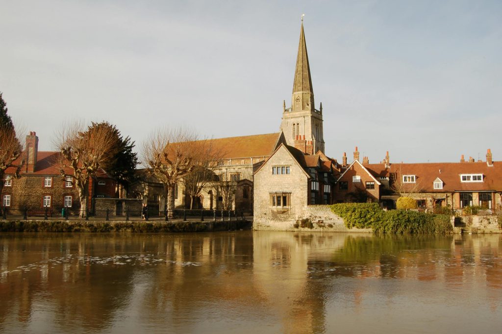 Scenic view of St Helen's Church in Abingdon, UK, showcasing historic architecture by the Thames.