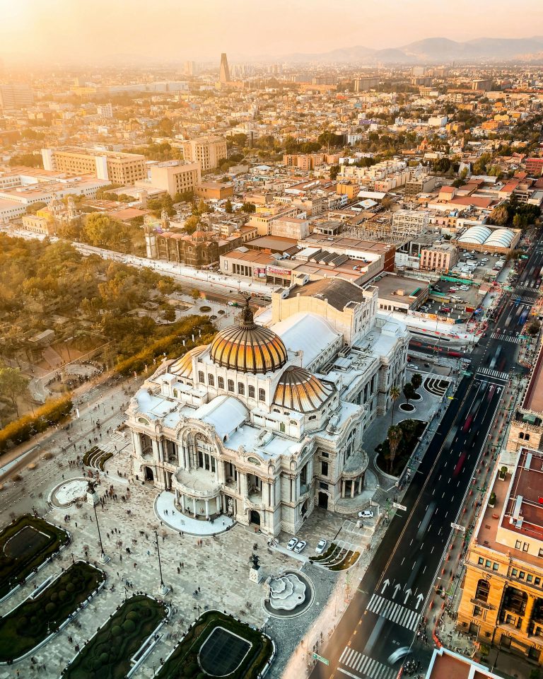 Stunning aerial photo of Palacio de Bellas Artes in Mexico City at sunset, showcasing urban architecture.