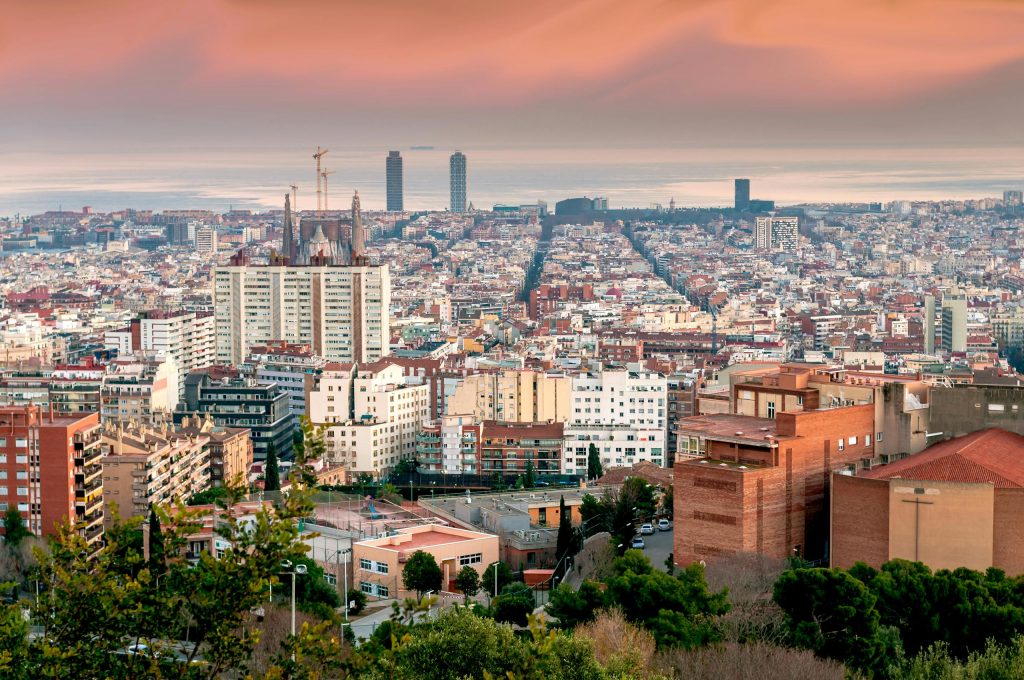 Stunning aerial view of Barcelona's vibrant cityscape during sunset.