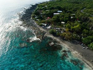 Stunning aerial view of Honaunau-Napoopoo's coastline showcasing lush greenery and clear waters.