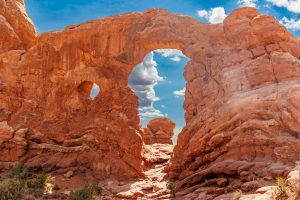 Stunning red rock arch in Kanab, Utah under a bright blue sky.