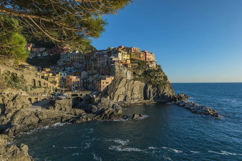 Stunning view of colorful Manarola perched on the rugged cliffs of Cinque Terre at sunset.
